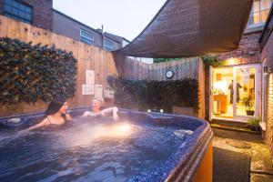 two women in a hot tub in a backyard at Chester Apartments in Chester