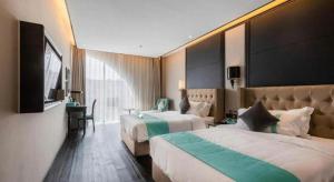 une chambre d'hôtel avec deux lits et une télévision à écran plat dans l'établissement Xana Hotelle Rizhao Lanshan District Government, à Lanshantou 136 autres photos