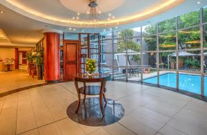 a living room with a table and a swimming pool at City Lodge Hotel Bryanston in Johannesburg