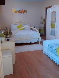 1 dormitorio con cama blanca y suelo de madera en Casarao dos Reis, en Caravela