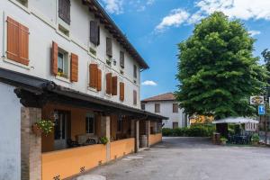 a street with a building and a tree at Ristorante Albergo Al Donatore in Teòr