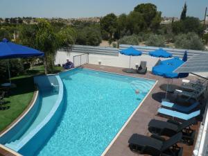 a swimming pool with blue umbrellas and chairs at Esperando in Maroni