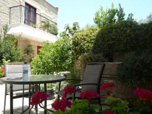a table and chairs and flowers on a patio at Esperando in Maroni