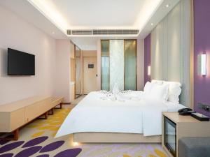 a bedroom with a large white bed and a flat screen tv at Lavande Hotel Jieyang Danpu in Jieyang +108 photos