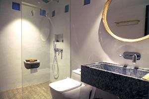 a bathroom with a sink and a toilet and a mirror at Qingyuan Zhilin Hot Spring Bed and Breakfast in Qingyuan