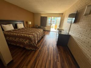 a hotel room with a bed and a television at Economy Inn in Belleville +8 photos