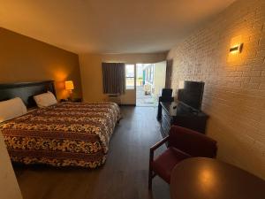 a hotel room with a bed and a television at Economy Inn in Belleville