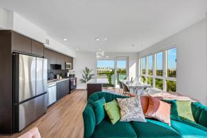a living room with a green couch and a kitchen at One Lux Stay - Hollywood in Los Angeles
