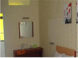 une salle de bain avec un miroir et un lavabo dans l'établissement Shantou Jun Yue Business Hotel Tongyi Road Branch, à Batou