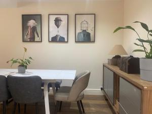 a dining room with a table and chairs and pictures on the wall at Three Bedroom House in Central Richmond in Richmond upon Thames +20 photos
