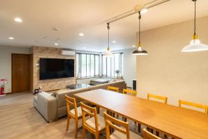 a dining room and living room with a table and chairs at Grandir Hiraoka グランディール平岡 フルリフォーム 広々戸建 ファミリーオススメ in Sapporo