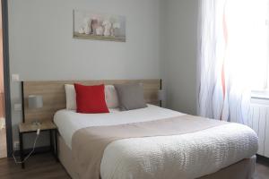een slaapkamer met een groot bed met rode kussens bij Logis Hôtel La Résidence, Cognac Centre in Cognac