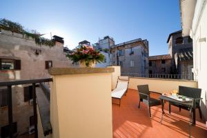 balkon ze stołem i wazą kwiatów w obiekcie Navona Palace Luxury Inn w Rzymie