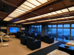 a conference room with chairs and a flat screen tv at NorthStar Sea Breeze Holiday Home in Shimoda