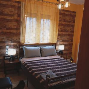 a bedroom with a bed with two lamps and a window at DREAM Home Ioannina in Ioannina