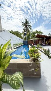 una piscina con piante di fronte a un edificio di Hotel Gili Trawangan & Dive a Gili Trawangan