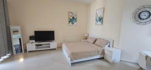 a bedroom with a bed and a flat screen tv at Nice Al Marjan studio in Ras al Khaimah
