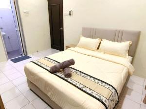 a bedroom with a bed with a towel on it at Lighthouse Tmn Intan 6pax Water Dispenser Neflix Target in Kluang
