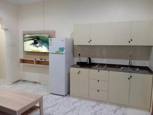 a kitchen with a white refrigerator and a table at شقق ابراج الخير in Abha