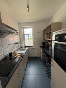a kitchen with a sink and a stove at Ferienwohnung Stein-16 zum Prinzenweg in Oberhof