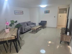 a living room with a couch and tables and chairs at Vila Lidar in Eilat