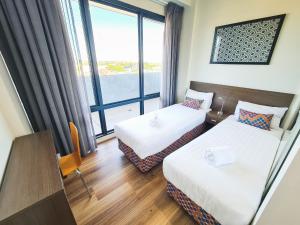 Postel nebo postele na pokoji v ubytování Exodus Dandenong Apartment Hotel