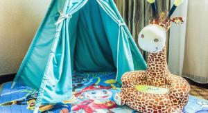two stuffed giraffes are sitting on a bed at Nanning Yongjiang Hotel in Nanning