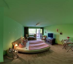 Hotel Merkurwald - Restaurant Wolpertinger في بادن بادن: غرفة معيشة مع سرير في وسط غرفة