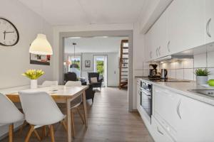 a kitchen and dining room with a table and chairs at Summer House On Beautiful Rømø! in Sønderby