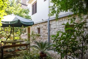 a patio with an umbrella and a bench at Azur Apartment in Budva