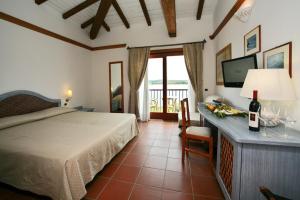 a bedroom with a bed and a table with a bottle of wine at Hotel Palumbalza Porto Rotondo in Porto Rotondo