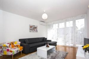 a living room with a black couch and a table at Dream Apartment Rijeka 3 in Rijeka