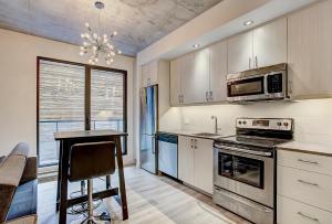 a kitchen with a stove and a microwave at The Downtown Oasis in Montréal