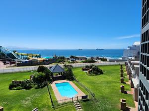 an aerial view of a building with a swimming pool and the ocean at Beautiful Sea view apartment 45 De Valle Diaz Mosselbay in Mossel Bay