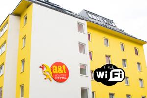 ein gelbes Gebäude mit zwei Aufklebern an der Seite in der Unterkunft a&t Holiday Hostel in Wien