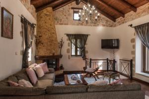a living room with a couch and a fireplace at Villa Fabrica in Thimiá