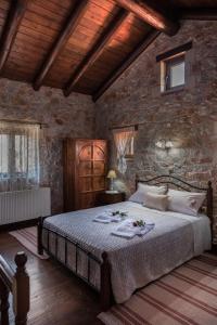 a bedroom with a large bed in a stone wall at Villa Fabrica in Thimiá