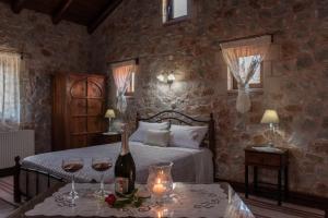 a bedroom with a bed and two glasses of wine at Villa Fabrica in Thimiá +28 photos