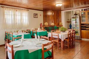 a restaurant with tables and chairs with green tablecloths at Casa Baranda in Vilar da Veiga