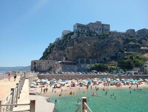 a group of people on a beach with a castle at palazzo sardanelli camera in Pizzo +59 photos