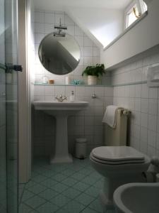 a bathroom with a sink and a toilet and a mirror at Guest House Vitaja in Bled