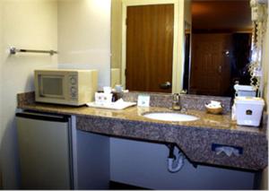 a bathroom with a sink and a microwave on a counter at Cloverdale Wine Country Inn & Suites in Cloverdale +14 photos