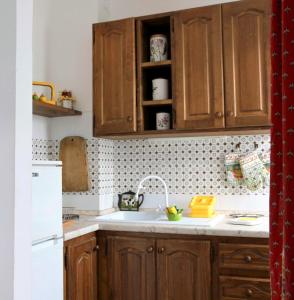 uma cozinha com armários de madeira e um lavatório em House I Cardi by Holiday World em Entracque