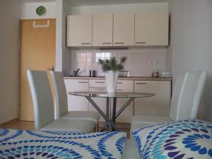 een keuken met een tafel en stoelen met een vaas erop bij Apartment Kanita in Moravske-Toplice