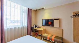Pokój hotelowy z łóżkiem i biurkiem z telewizorem w obiekcie IU Hotel Tianjin Youyi Road Meijiang Exhibition Meiniu Metro Station w mieście Tiencin