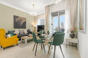een woonkamer met een bank, een tafel en stoelen bij Burj View Downtown 1BR Dubai in Sabkhah