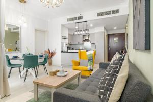 een woonkamer met een bank en een tafel bij Burj View Downtown 1BR Dubai in Sabkhah