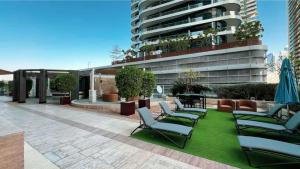 een groep stoelen en parasols op een terras bij Burj View Downtown 1BR Dubai in Sabkhah
