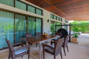 a dining room with a wooden table and chairs at Villa Oxavia in Rawai Beach
