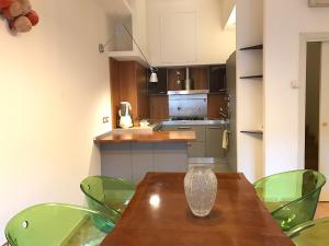 a kitchen with a wooden table and green chairs at Elegante in centro in Imola